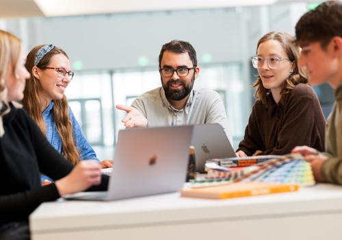 Students in the graphic design program discuss a project with their instructor. 