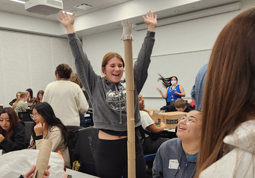 Upward Bound student Catrina Rulla celebrates the completion of the community service project. She is wearing gray sweats and has her hair pulled back in a pony tail. 