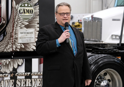 Ed Koster stands in front of a Crete Carrier cab decorated for D-Day. 