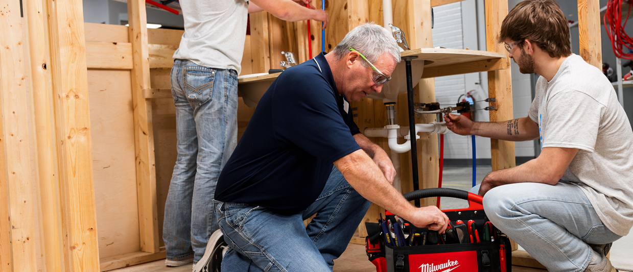 Students and instructor working on plumbing in an SCC classroom. 