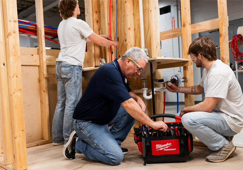 Students and instructor working on plumbing in an SCC classroom. 