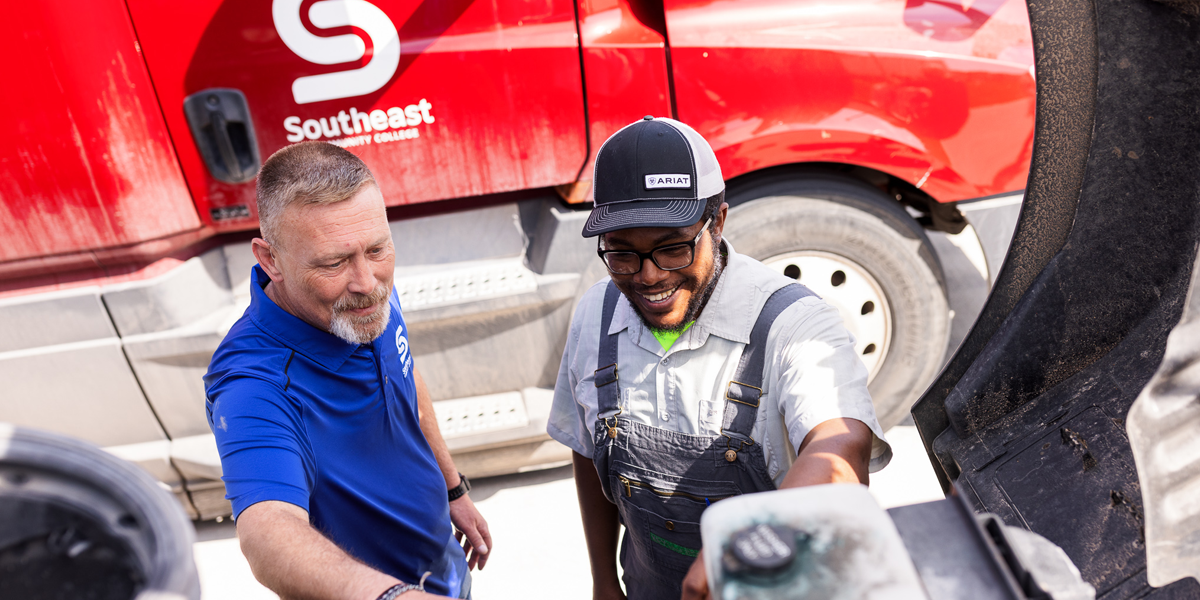 Instructor and student working on semi-truck